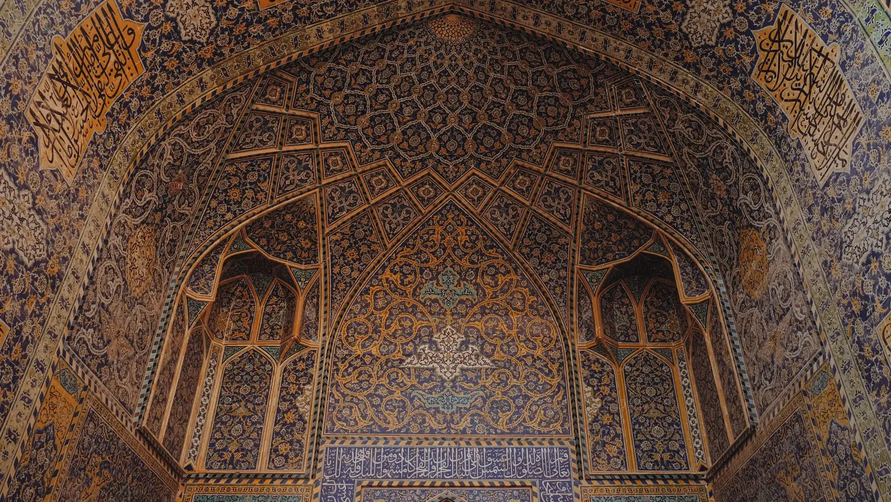 The tiled vault of a mosque arch, worked in gold and indigo arabesque.
