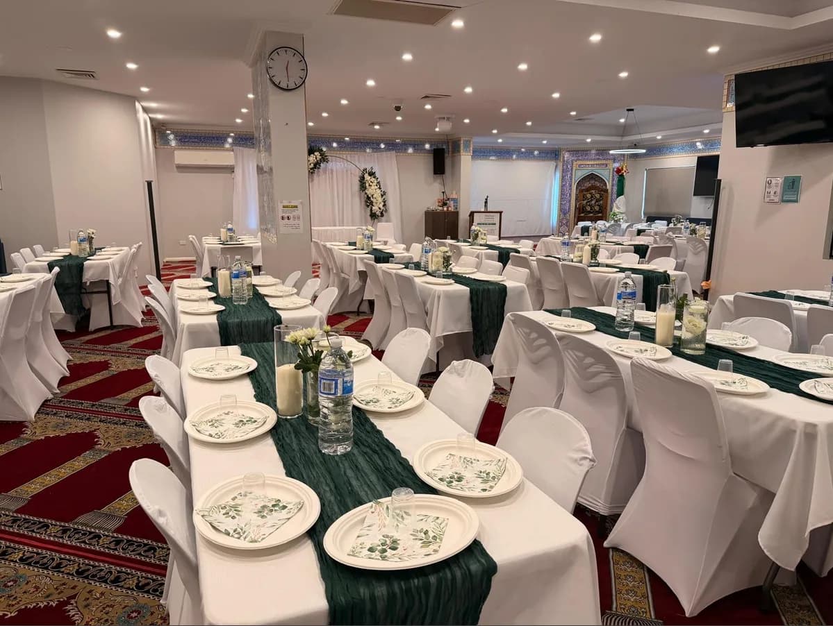 The centre's hall laid out with tables and place settings for a function.