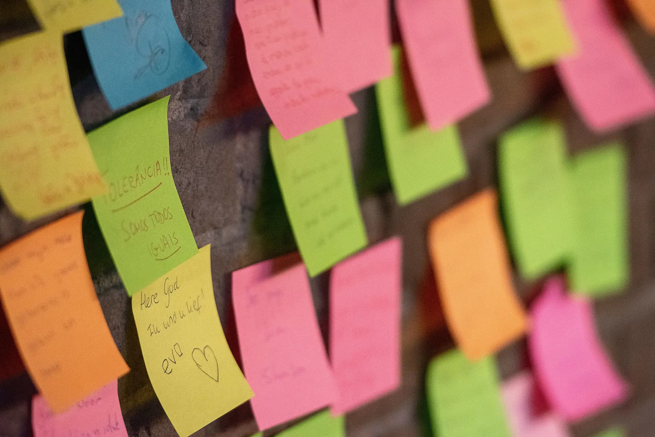 A wall covered in handwritten notes left by visitors.